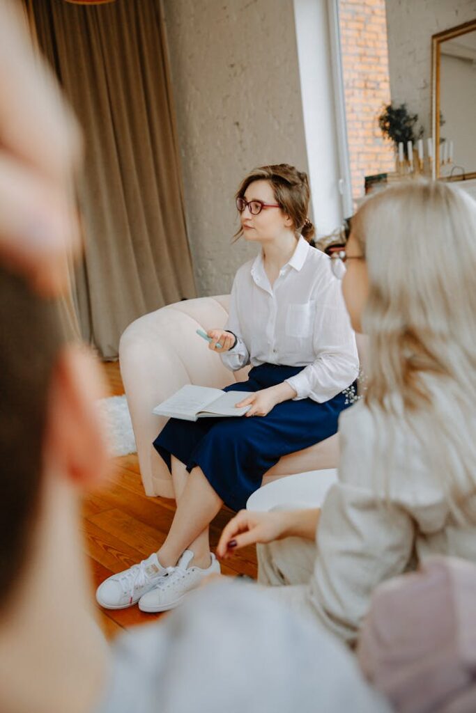 A therapist leading a counseling session with a couple in a cozy room setting.